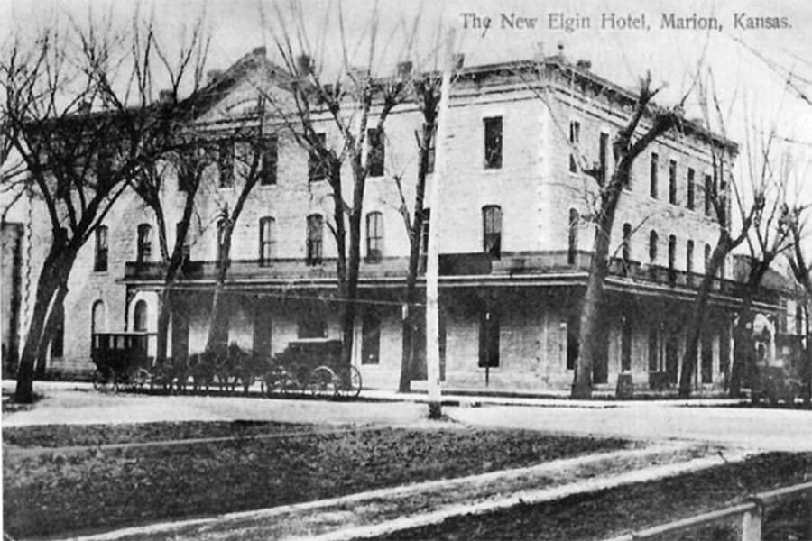 Black and white photo of The New Elgin Hotel in Marion, Kansas, surrounded by bare trees.
