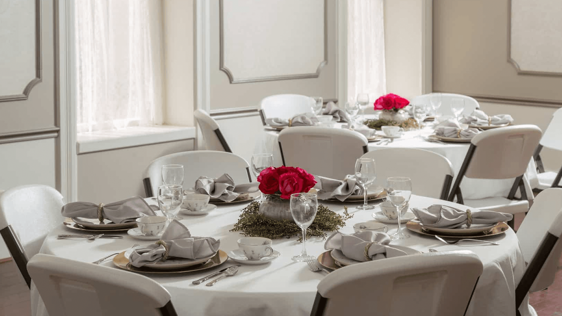 Wedding reception setup at Historic Elgin Hotel in Marion, Kansas, featuring elegantly decorated round tables with floral centerpieces, fine china, and soft natural lighting.