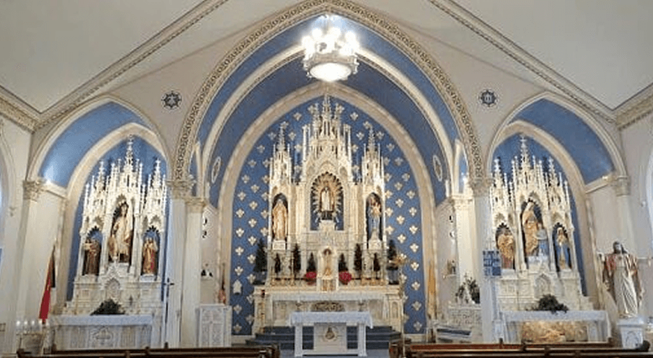 Interior view of a church altar featuring ornate decorations and religious sculptures.